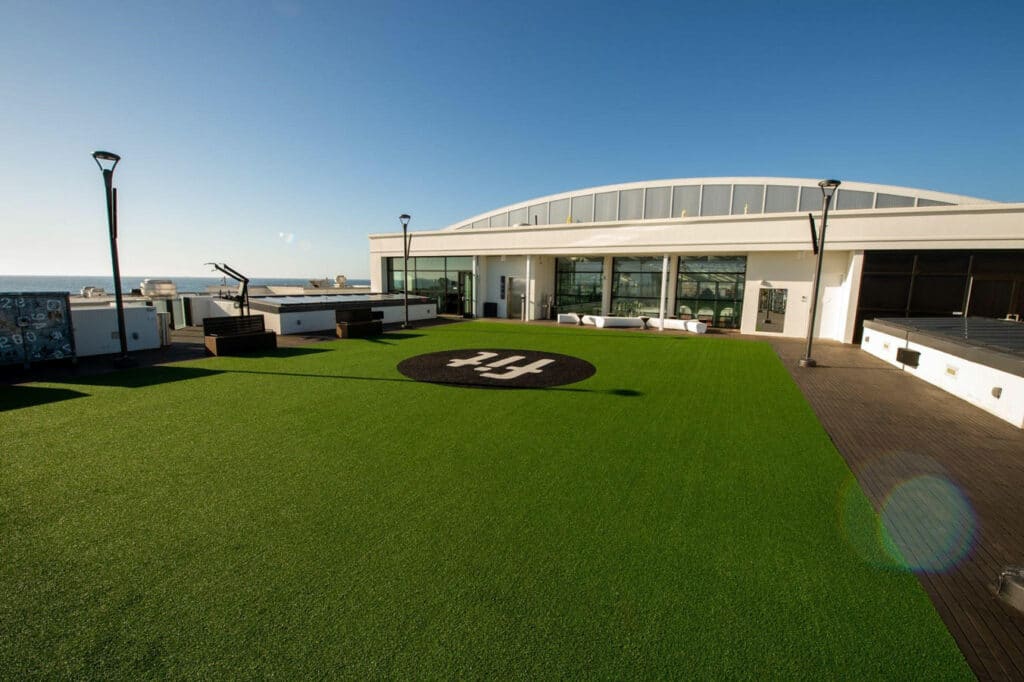 A rooftop with artificial grass and a view of the ocean.