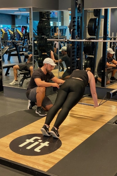 A woman doing a squat in a gym.