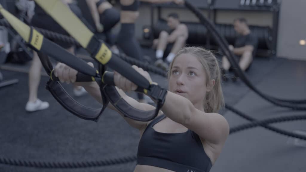 A man wearing a black t - shirt and gray pants.
