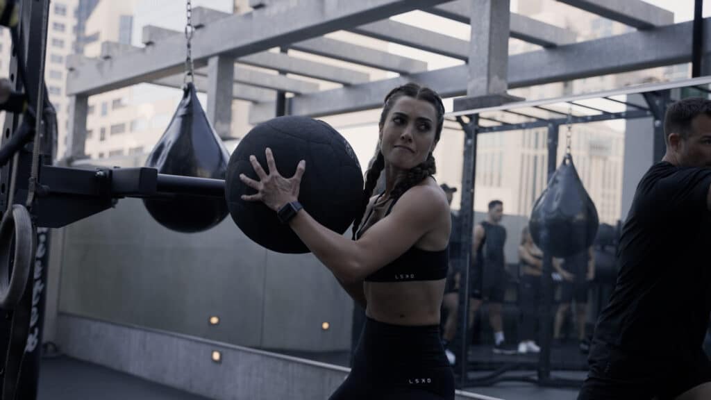 A woman doing a trx workout in a gym.