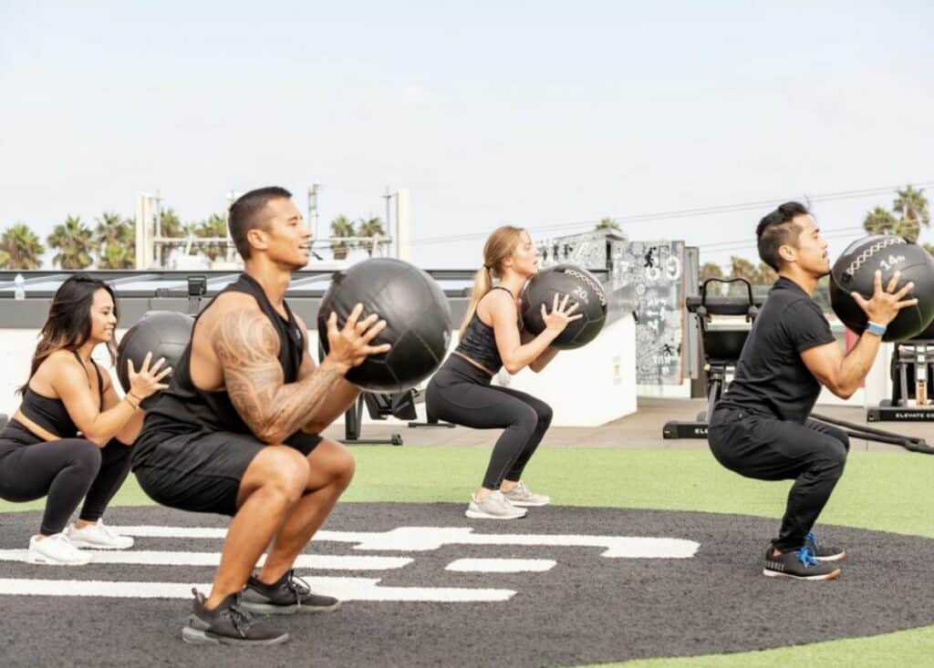 A man and woman posing for a photo in front of a gym.