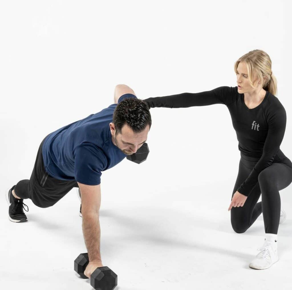 A man and woman doing push ups on a white background.
